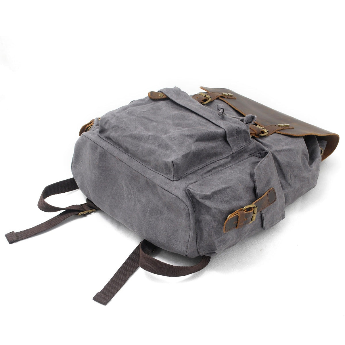 Gray waxed canvas backpack showing its exterior side pocket and leather buckle.