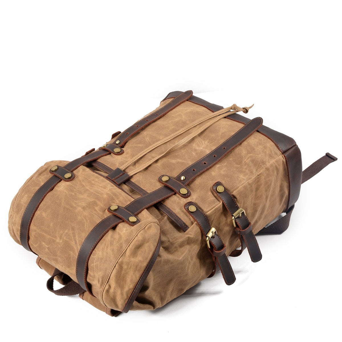Khaki waxed canvas backpack lying flat with straps closed