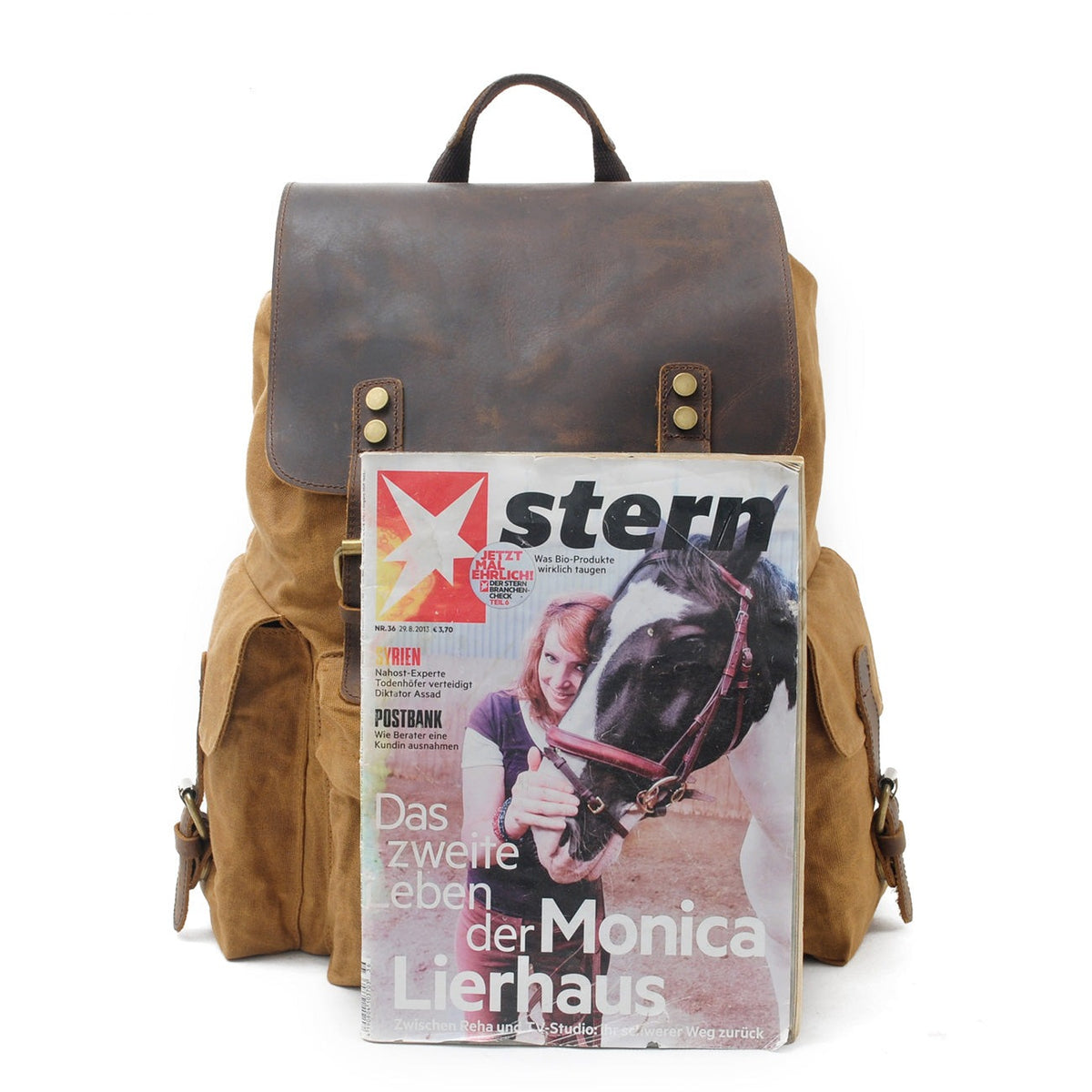 Khaki backpack held against a magazine to show its size