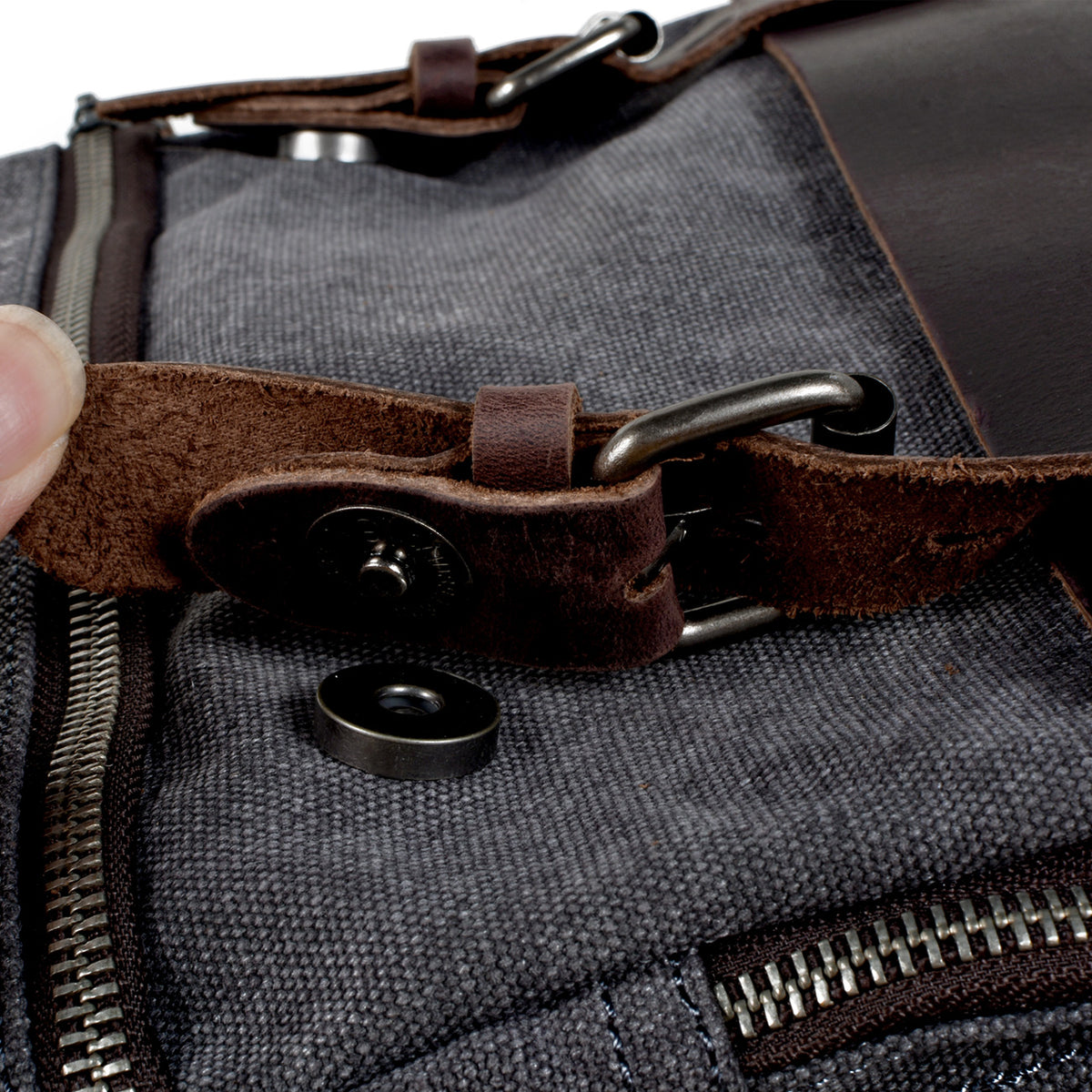 Magnetic snap beneath the leather buckle strap, shown open