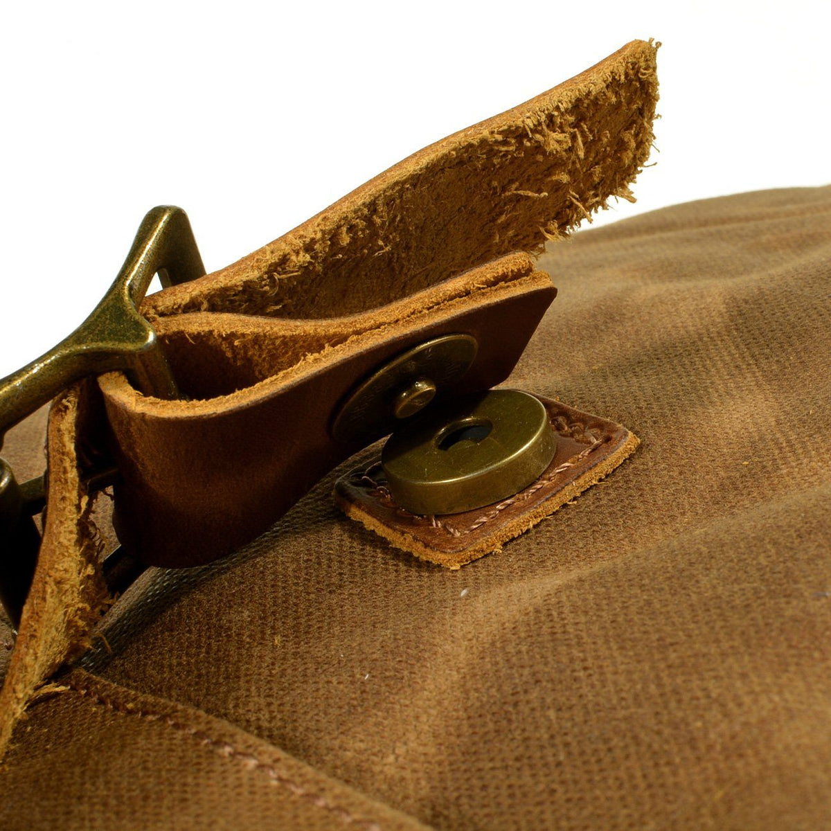 Close-up of the brass snap and leather tab on the front pocket