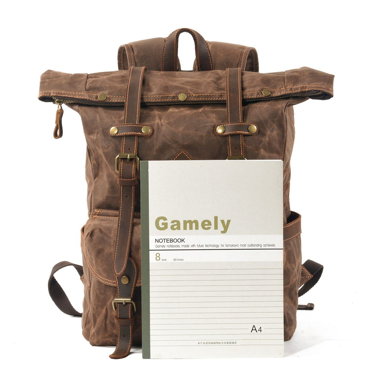 Coffee waxed canvas backpack with a notebook in front for size comparison.