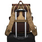 Camera backpack slipped over a rolling suitcase handle with its luggage strap
