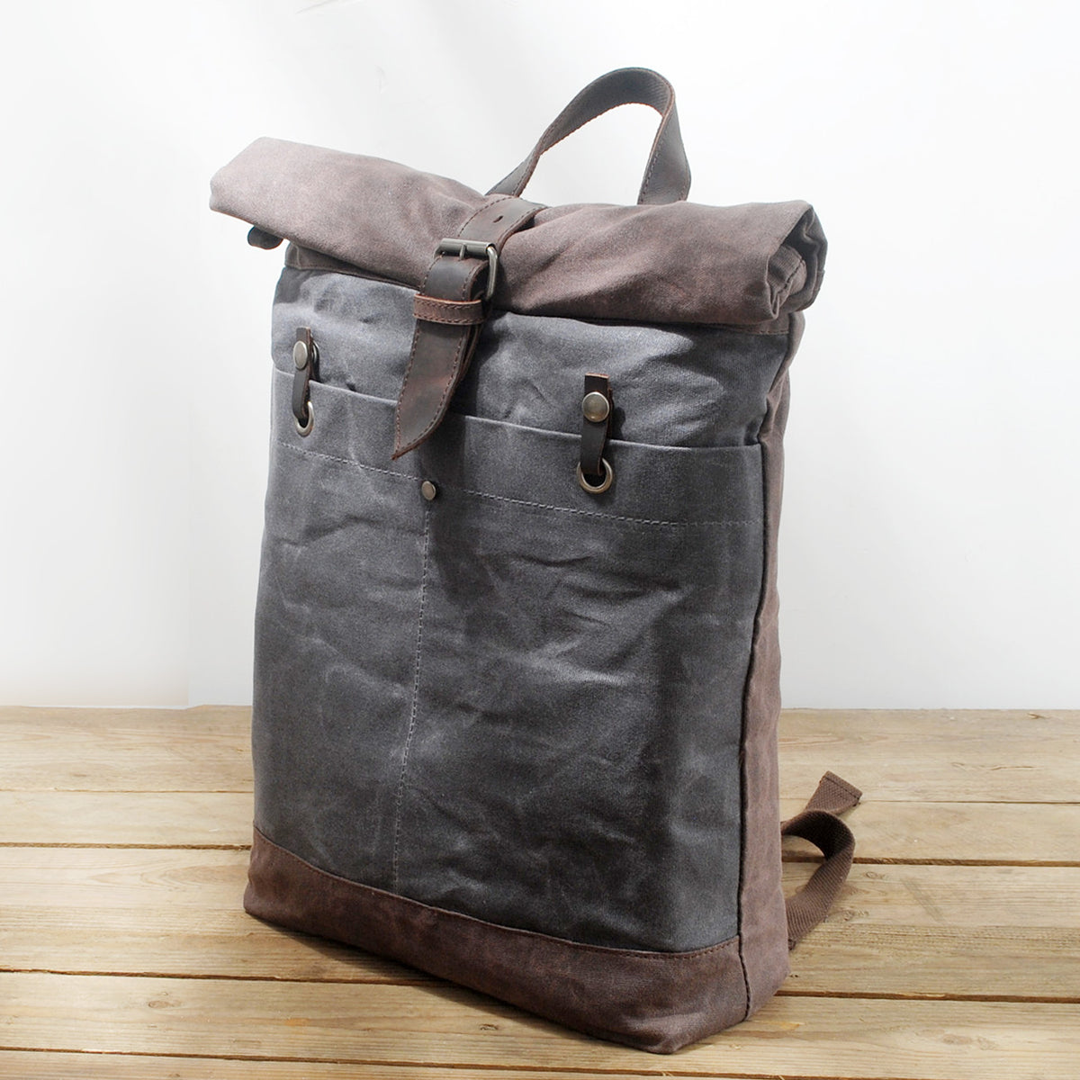 Gray waxed canvas backpack standing on a wooden table