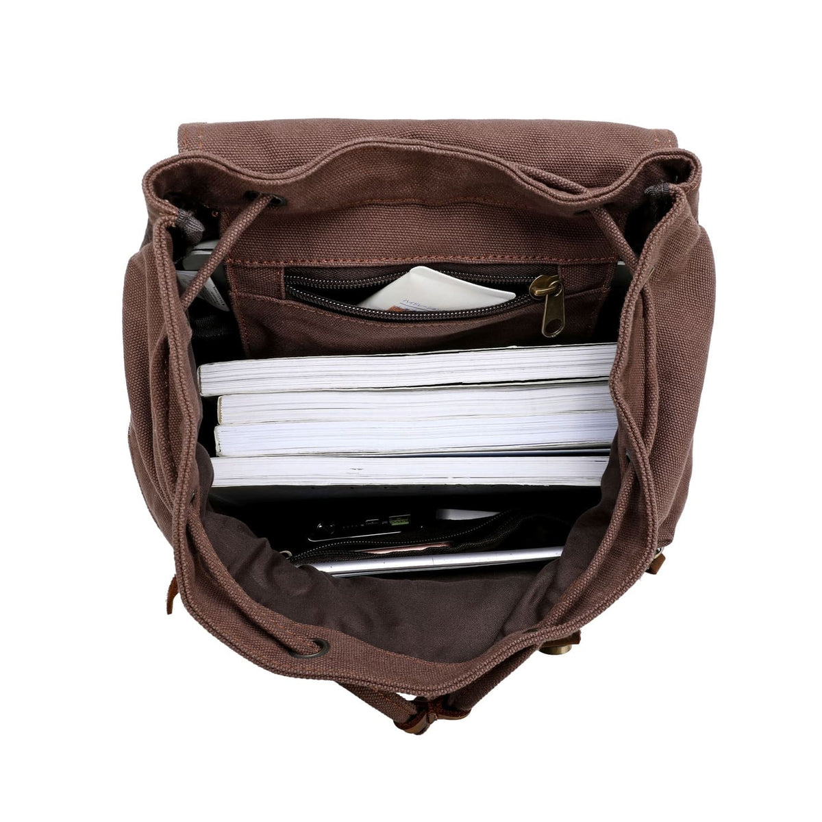 Open coffee canvas backpack packed with notebooks and daily essentials.