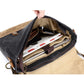 Messenger bag packed with a laptop, book and glasses inside its zippered main compartment
