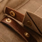 Brass snap on a leather strap of the khaki backpack
