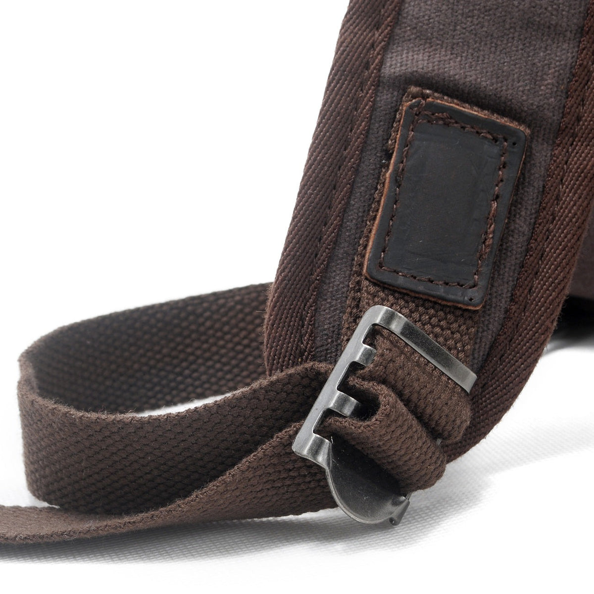 Shoulder strap with a metal slider and leather label on the gray backpack
