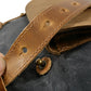 Leather strap and turn-lock snap on the gray canvas