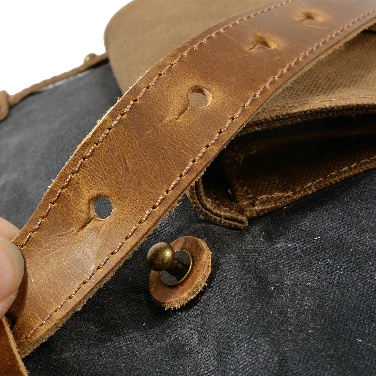 Leather strap and turn-lock snap on the gray canvas
