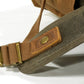 Riveted shoulder strap and brass slider on the army green backpack