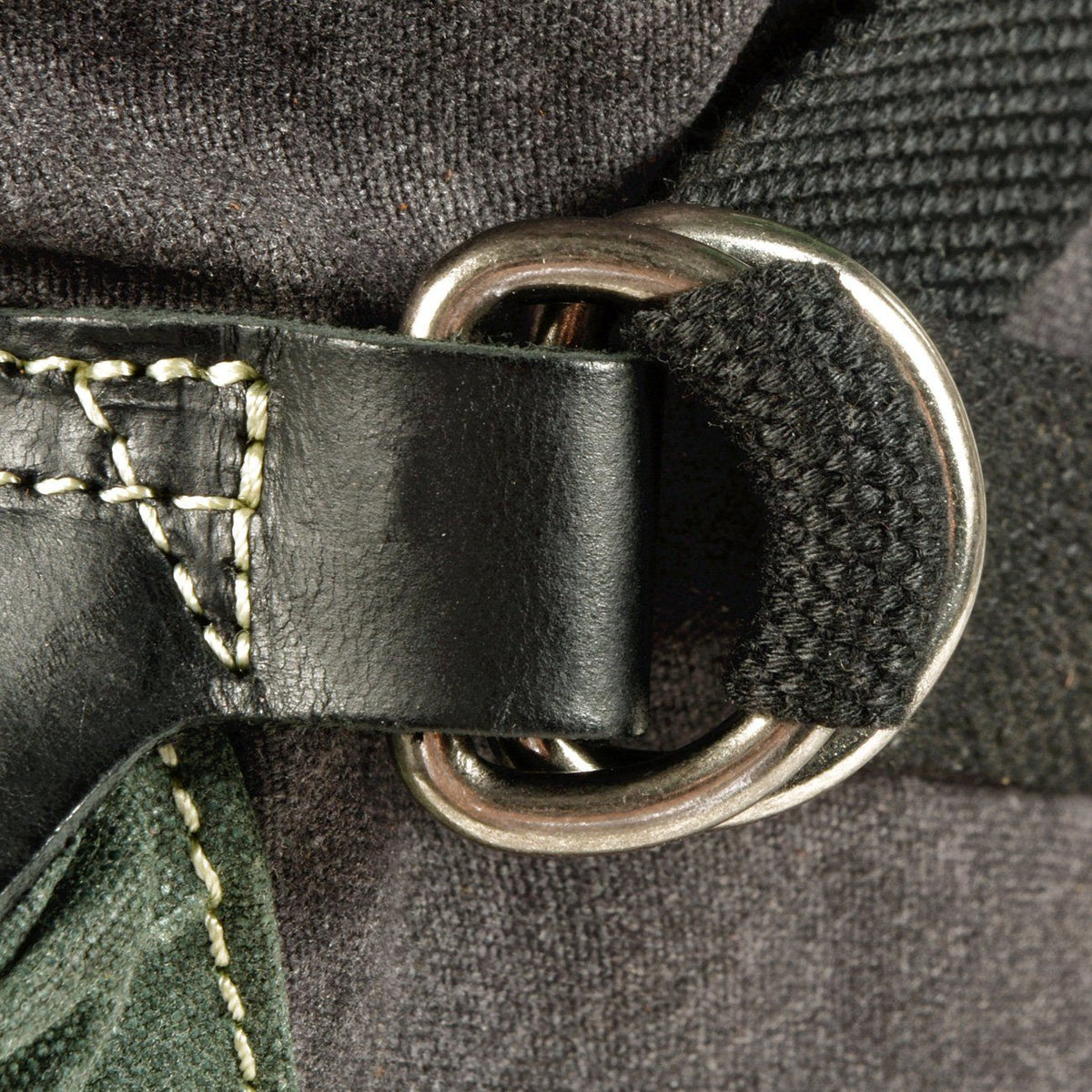 Close-up of a metal D-ring with a webbing strap and stitched leather attachment on the backpack