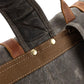 Brass rivets securing the webbing strap on the gray backpack