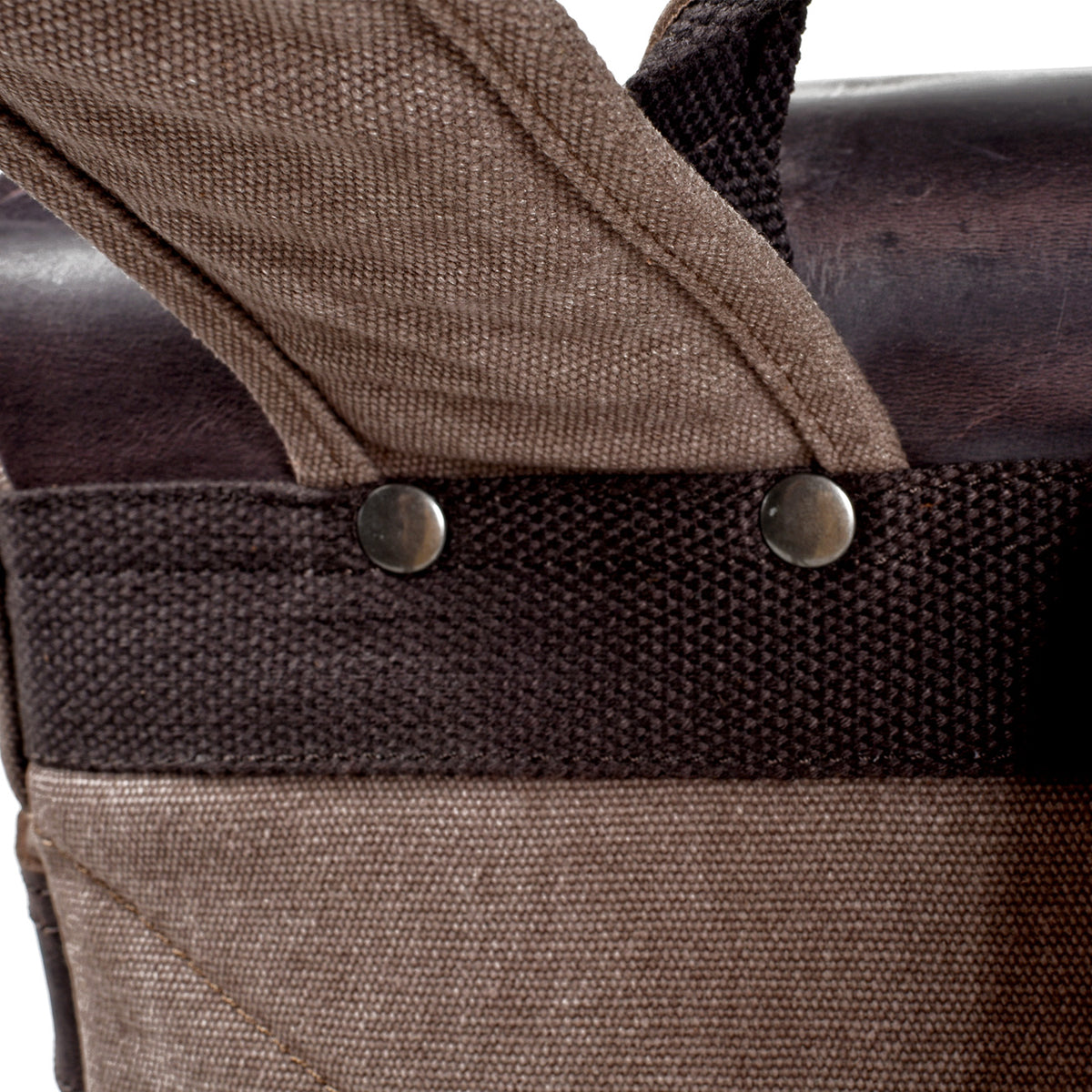 Two rivets anchoring the shoulder strap to the reinforced back panel