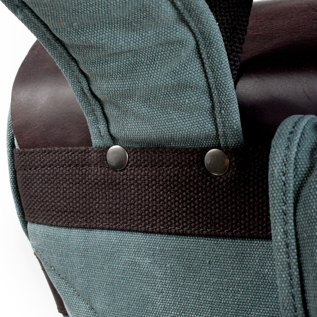 Riveted shoulder strap attachment above the woven reinforcement strip