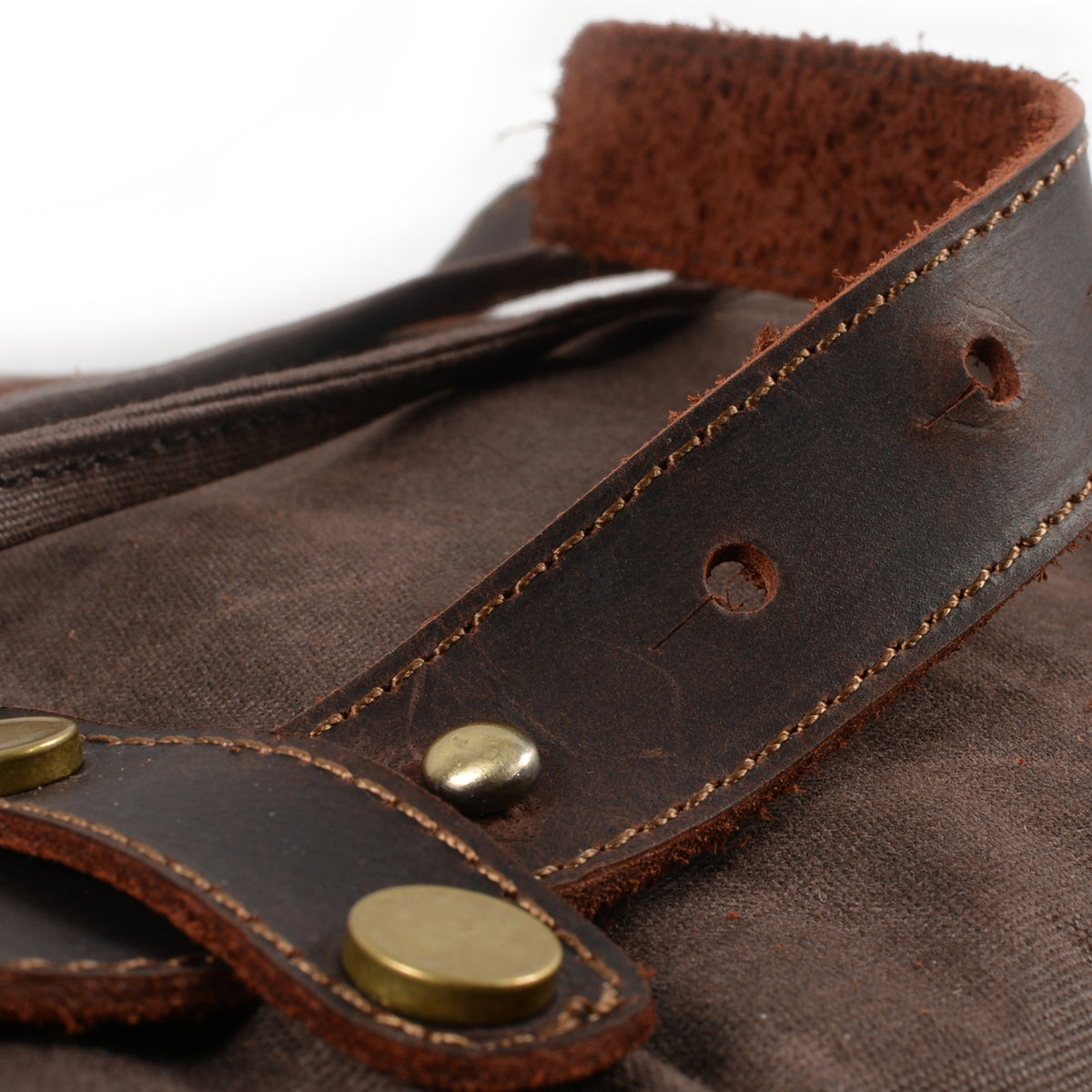 Leather strap tab with brass rivets on Coffee waxed canvas.