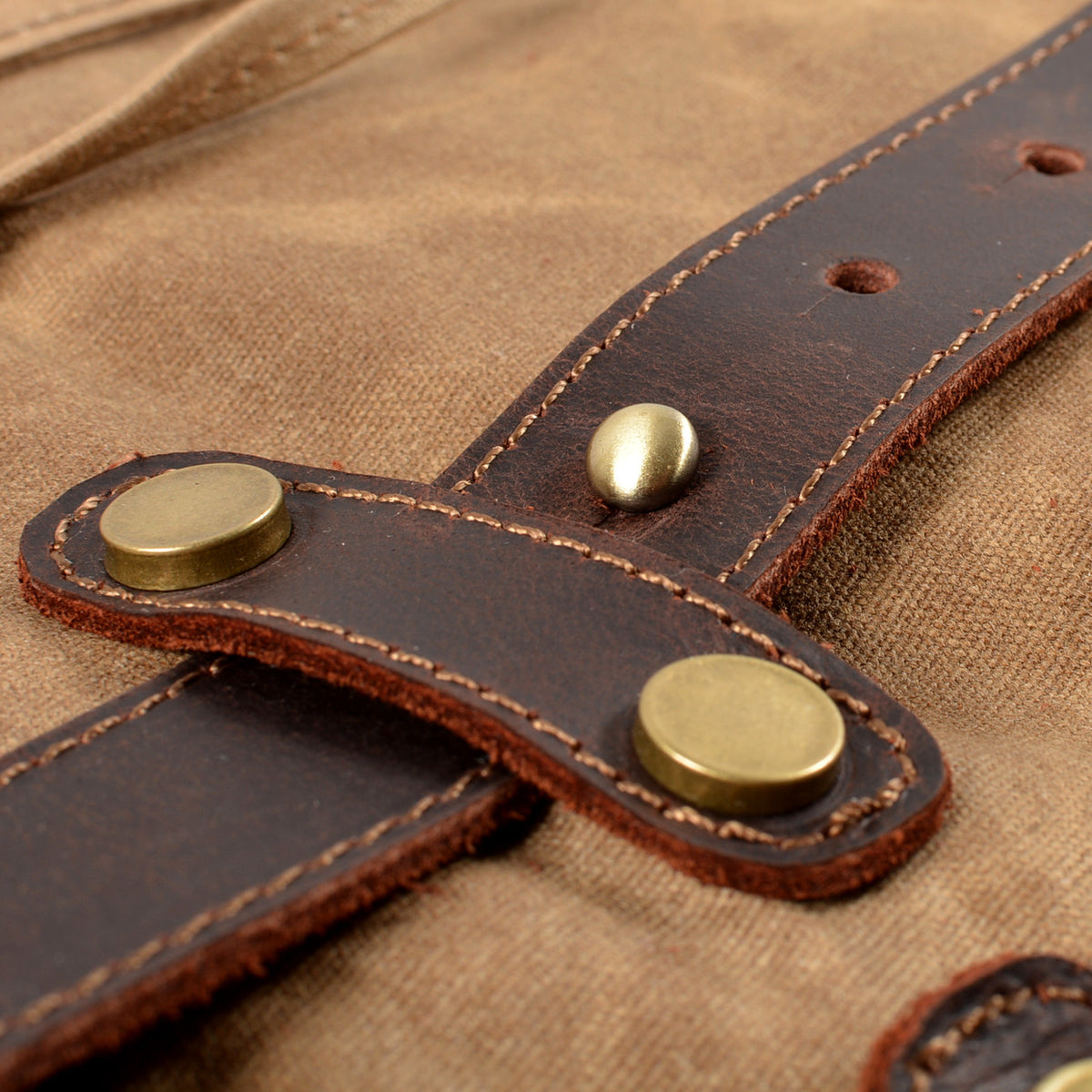 Riveted leather strap tab on Khaki waxed canvas.