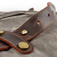 Riveted leather strap tab on Gray waxed canvas.