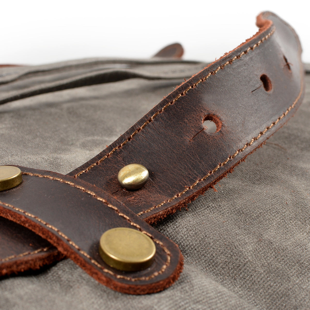Riveted leather strap tab on Gray waxed canvas.
