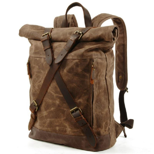 Three-quarter view showing the backpack's side panel, rolled closure and adjustable shoulder strap