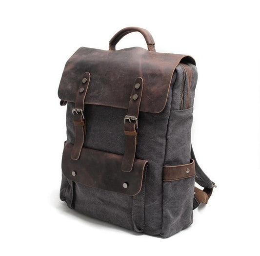 Three-quarter view of the Dark Gray canvas rucksack with its leather top handle.