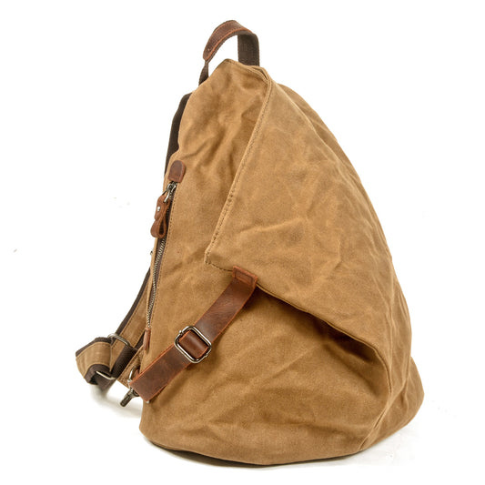 Khaki waxed canvas backpack at an angle, showing side zipper and buckled leather strap.