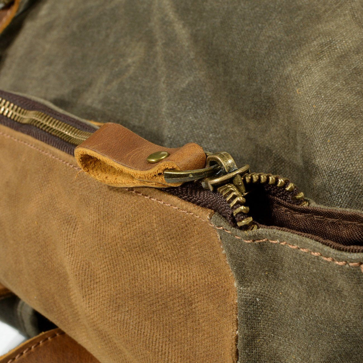 Metal zipper and leather pull on the waxed canvas